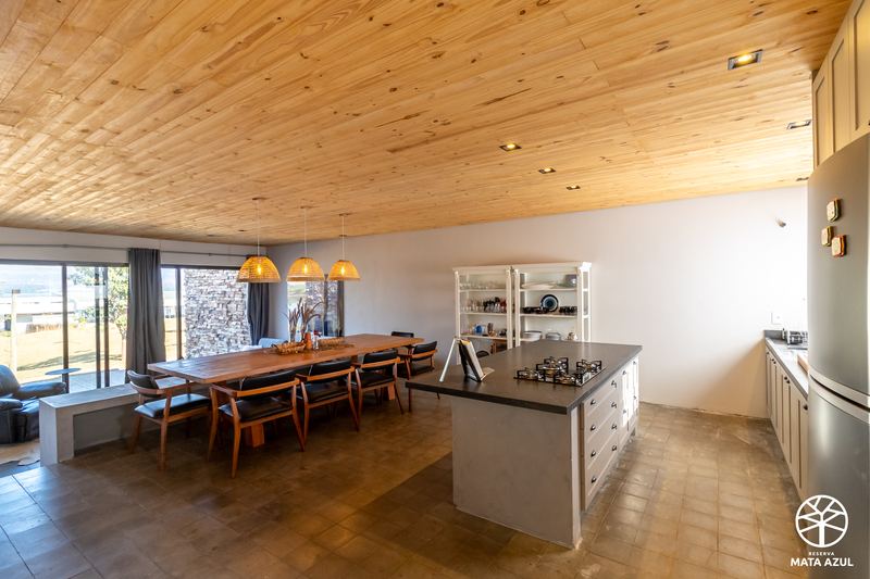 Cozinha do loft, com ilha central e forro de madeira