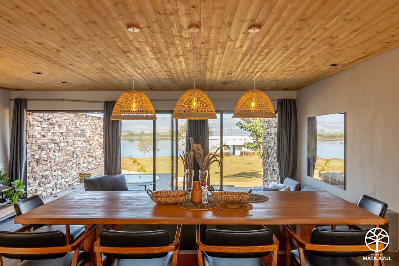 Sala de jantar do loft, com vista para a represa pela janela