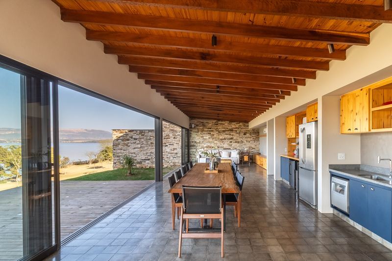 Sala e cozinha integradas de uma casa, abertas para a represa