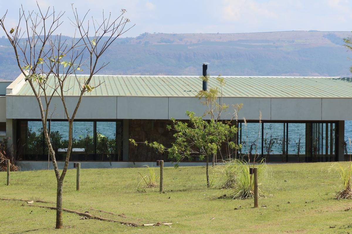 Club House da Reserva Mata Azul visto do gramado, com a represa e a serra ao fundo
