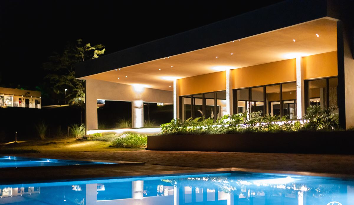Club House e piscina iluminados à noite